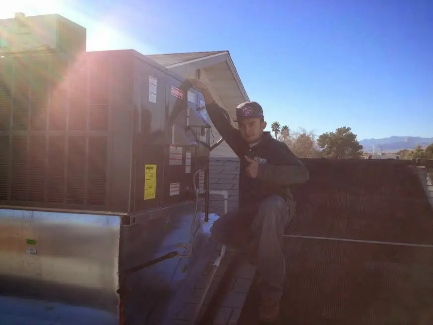 HVAC technician performing AC Tune-Up on a rooftop unit in Morris